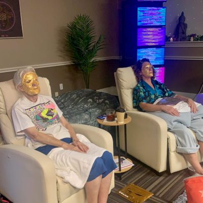 Two women relaxing with gold face masks.